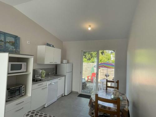 une cuisine avec une table et une salle à manger dans l'établissement Petite maison neuve à 250m de la plage avec jardin clos, terrasse et parking - L'Épine - FR-1-224B-190, à LʼÉpine