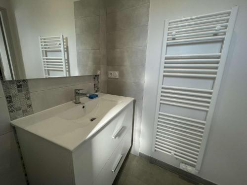 une salle de bain blanche avec un lavabo et un miroir dans l'établissement Petite maison neuve à 250m de la plage avec jardin clos, terrasse et parking - L'Épine - FR-1-224B-190, à LʼÉpine