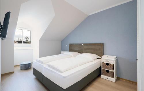 um quarto com uma cama grande e lençóis brancos em Baltischer Hof Apartment 64 em Boltenhagen