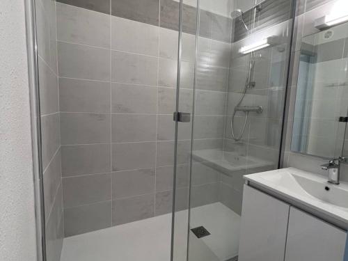 une salle de bain blanche avec une douche et un lavabo dans l'établissement Appartement T2 avec Terrasse, Proche Plage, Le Barcarès - FR-1-81-589, au Barcarès