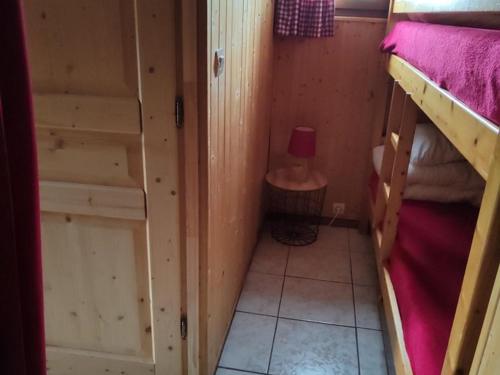 Cette petite chambre comprend 2 lits superposés et une lampe. dans l'établissement Studio cosy 4 pers, RDC, Sud, à 300m des pistes et 250m commerces, bien équipé, animaux admis. - FR-1-733-116, à Crest-Voland