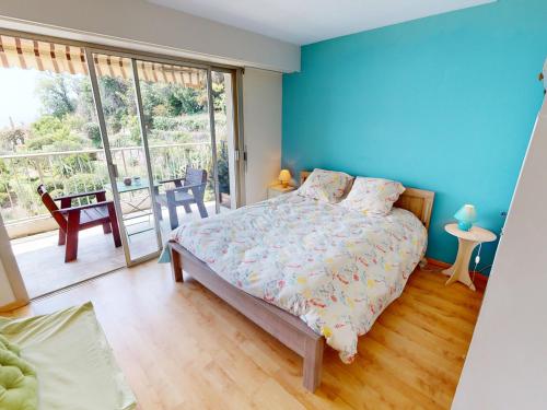 a bedroom with a bed with a blue wall at Grand 3P à Menton avec terrasses et parkings - FR-1-196-331 in Menton