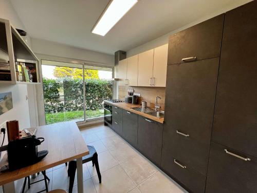 une cuisine avec une table et une grande fenêtre dans l'établissement Appartement 3 pièces rénové, proche plage et côte sauvage avec jardin et parking - Quiberon - FR-1-478-252, à Quiberon