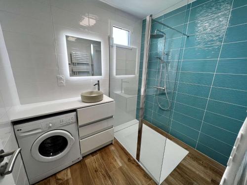 La salle de bains est pourvue d'un lave-linge et d'une douche. dans l'établissement Appartement 3 pièces rénové, proche plage et côte sauvage avec jardin et parking - Quiberon - FR-1-478-252, à Quiberon