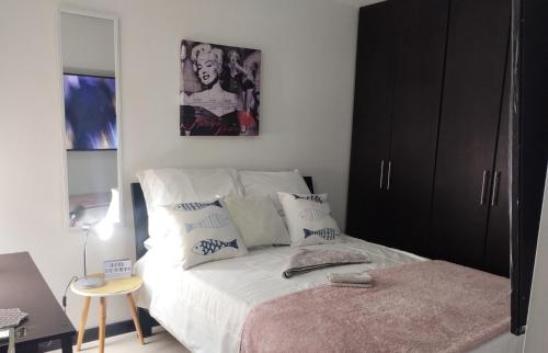 a bedroom with a bed with a black cabinet at Apartamento sector exclusivo acogedor in Bogotá