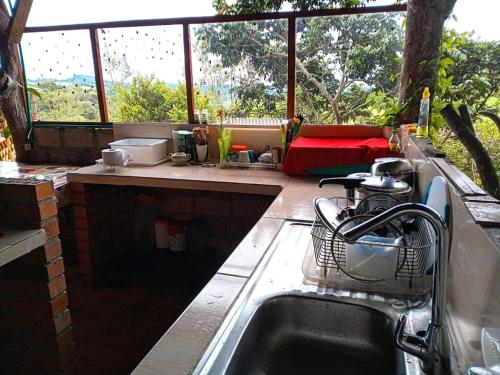 a kitchen with a sink in front of a window at Saranna Cabaña in San Agustín