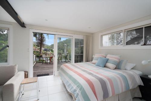 1 dormitorio con 1 cama y balcón en Gull Cottage by Beach Stays, en Church Point