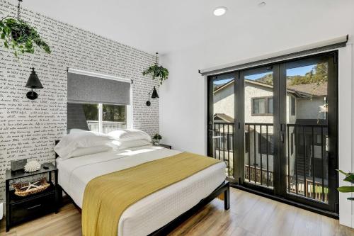 Un dormitorio con una cama y una ventana grande en Newly Built Modern Home w Ocean View Rooftop Deck, en Avalon