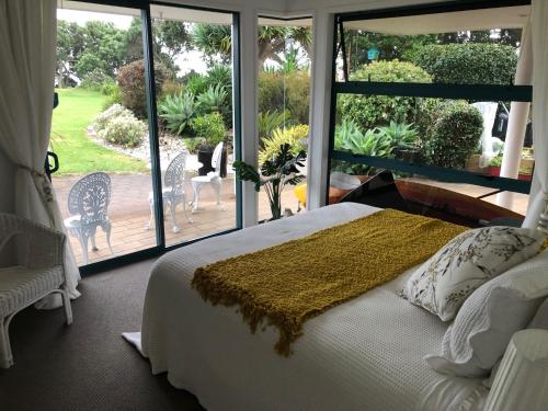 sypialnia z łóżkiem i dużym oknem w obiekcie Luxury Waterfront w mieście One Tree Point