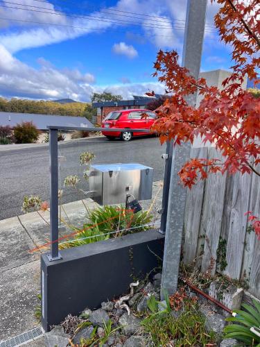 a red car parked in a parking lot next to a fence at Hobart View in Hobart