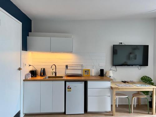 a kitchen with white cabinets and a sink and a table at Hobart View in Hobart