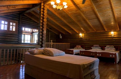 a bedroom with two beds in a log cabin at Log Cabin House in Lutong