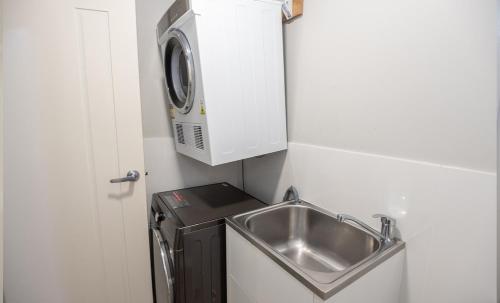a kitchen with a sink and a washing machine at Cardiff Executive Apartments in Newcastle