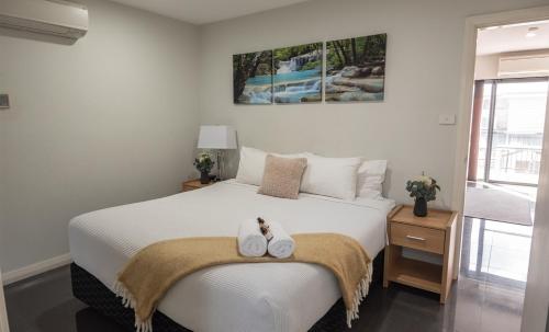 - une chambre avec un lit blanc et 2 serviettes dans l'établissement Cardiff Executive Apartments, à Newcastle