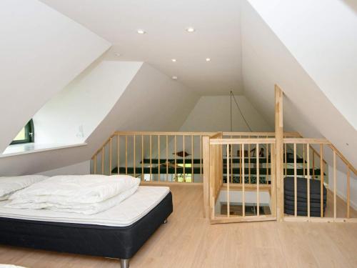 a attic bedroom with a bed and a staircase at Holiday home Varde IV in Varde