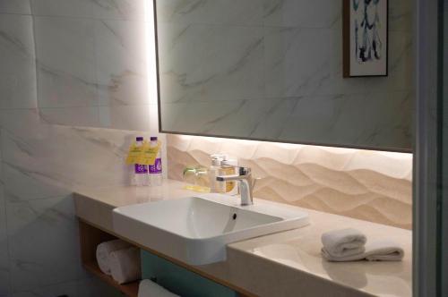 a bathroom with a white sink and a mirror at Holiday Inn Tianjin Xiqing by IHG in Tianjin