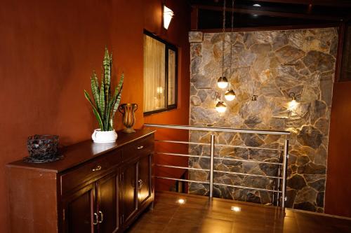 a walk in shower in a room with a stone wall at Apartamento con jacuzzi y Parqueadero in Cuenca