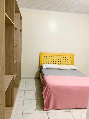 a bedroom with a bed with a pink blanket at Apartamento 1 dormitório, otima vista in Passo Fundo