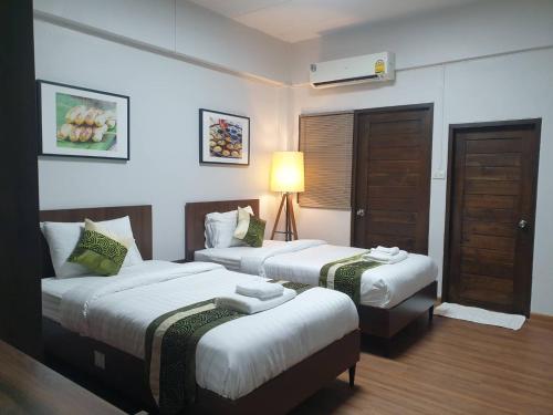 เตียงในห้องที่ The Bedrooms Maeklong and Services Apartment