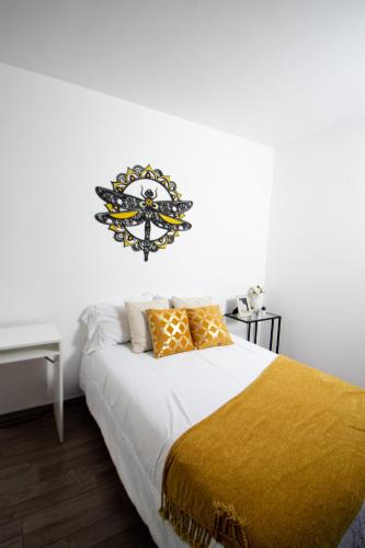 a bedroom with a large bed with a decorative sign on the wall at D HABITACION MANDALA NEBRASKA 63 in Mexico City