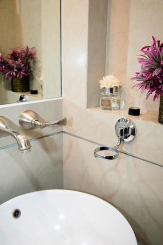 a bathroom with a sink and a mirror and flowers at D HABITACION MANDALA NEBRASKA 63 in Mexico City