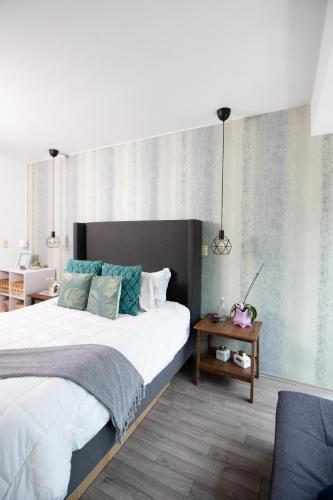 a bedroom with a large bed and a table at D HABITACION MANDALA NEBRASKA 63 in Mexico City