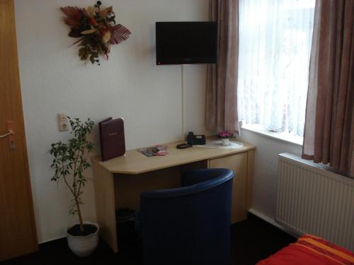 a room with a desk with a computer and a window at Hotel Bierstübl in Sangerhausen