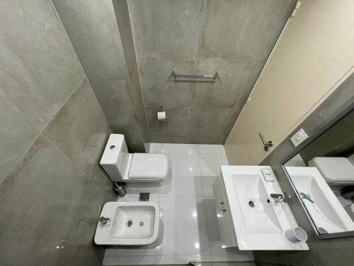 ein Badezimmer mit einem Waschbecken, einem WC und einem Spiegel in der Unterkunft Buenos Aires City in Buenos Aires