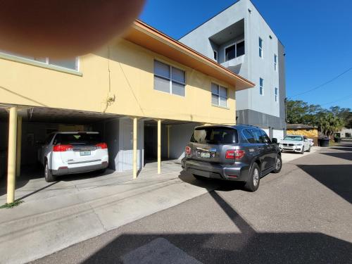 two cars parked in a parking lot next to a building at CLR St. Pete in St Petersburg