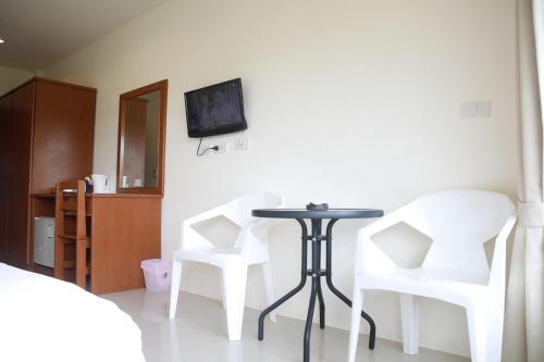 Habitación con 2 sillas blancas y mesa. en Choengmon Residence, en Choeng Mon Beach