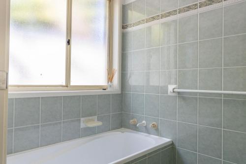 bagno con vasca e finestra di Peaceful Cul de sac a Sussex inlet