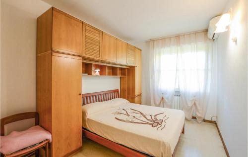 3 Bedroom Lovely Home In Marina Di Pietrasanta في مارينا دي بيتراسانتا: غرفة نوم بسرير وخزانة خشبية