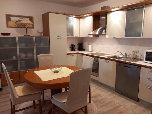 a kitchen with a wooden table and white cabinets at Olivia in Poreč