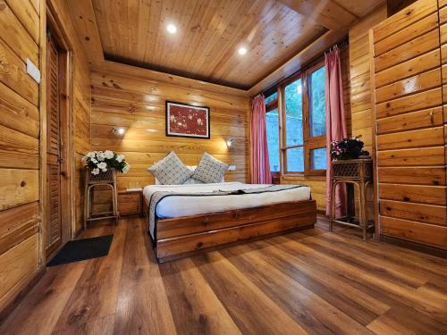 um quarto com uma cama num quarto com paredes de madeira em The Chalets Naldehra em Shimla