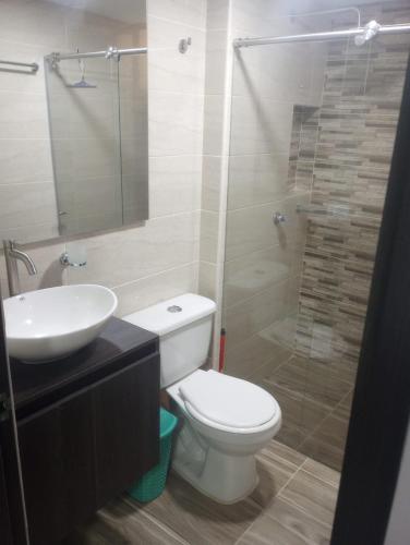 a bathroom with a toilet and a sink and a shower at Apartahotel in Ibagué