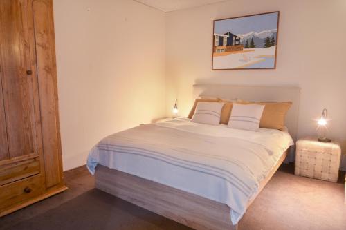 a bedroom with a large bed with white sheets and pillows at Twin Towers 102a in Mount Buller