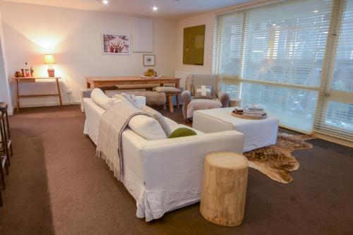 a living room with white couches and a table at Twin Towers 102a AMS Mt Buller in Mount Buller