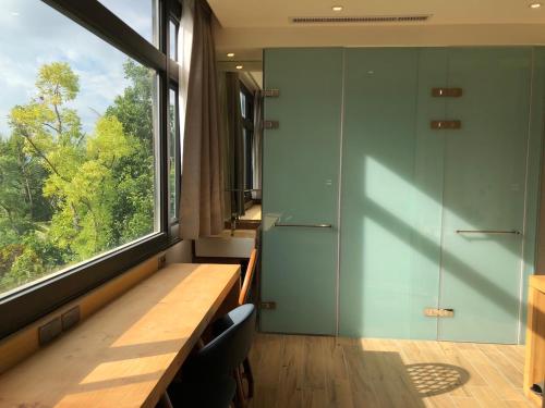 a room with a desk and a large window at La Tree 普椿農場木子莊園 in Donghe