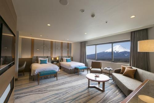 una camera d'albergo con due letti e un divano di Highland Resort Hotel & Spa a Fujiyoshida