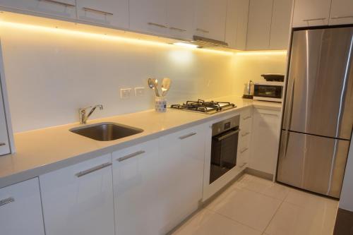 a kitchen with white cabinets and a stainless steel refrigerator at Alto Villa 403 in Mount Buller