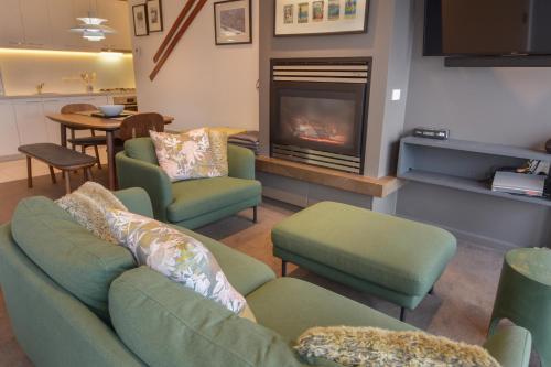 a living room with two couches and a fireplace at Alto Villa 403 in Mount Buller