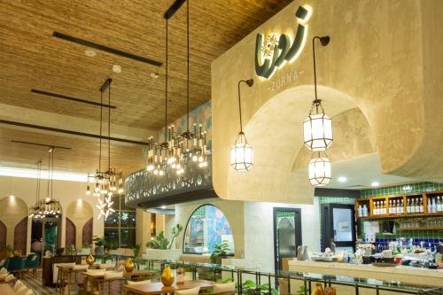 a restaurant with tables and chandeliers at Citadines Abha in Abha