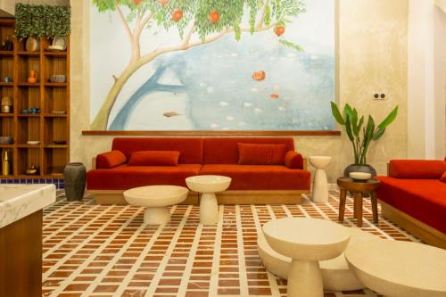 a living room with a red couch and a painting at Citadines Abha in Abha