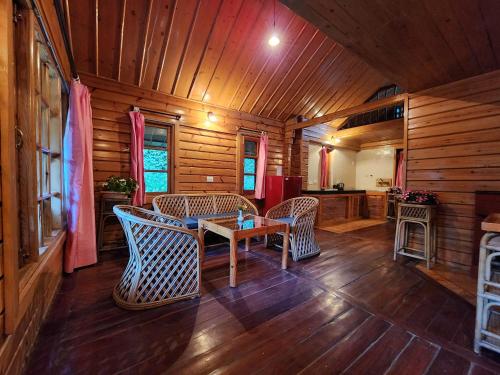 a room with a table and chairs in a cabin at The Chalets Naldehra in Shimla