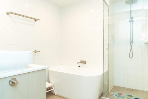 een witte badkamer met een wastafel en een douche bij Candoux 4 in Mount Buller