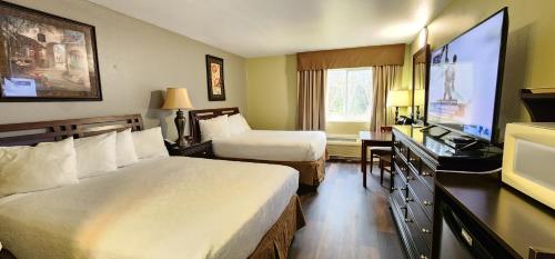 Habitación de hotel con 2 camas y TV de pantalla plana. en Crest Trail Lodge en Packwood