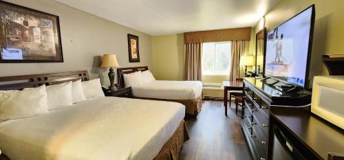 a hotel room with two beds and a flat screen tv at Crest Trail Lodge in Packwood