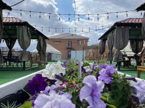 ein Blumenstrauß auf einer Terrasse mit Sonnenschirmen in der Unterkunft Apec Hotel in Atyrau