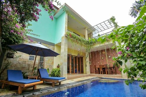 dom z basenem, 2 krzesłami i parasolem w obiekcie Jasmine Villa Senggigi w mieście Senggigi
