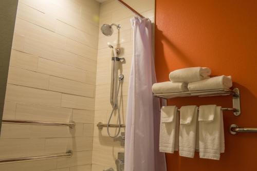 a bathroom with a shower with towels on a rack at Aloft Corpus Christi in Corpus Christi
